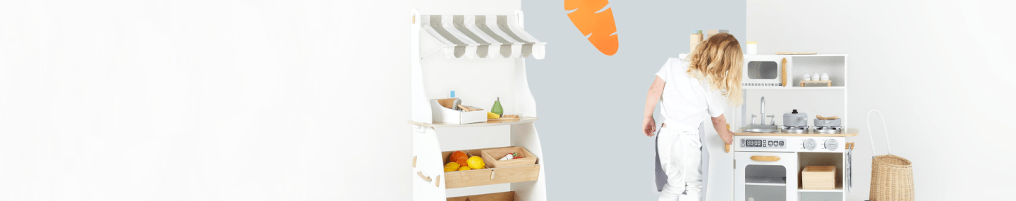 Little girl playing market stand and toy kitchen